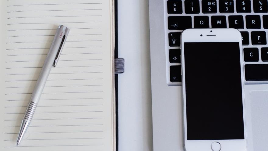 Teclado ordenador, teléfono, cuaderno y bolígrafo