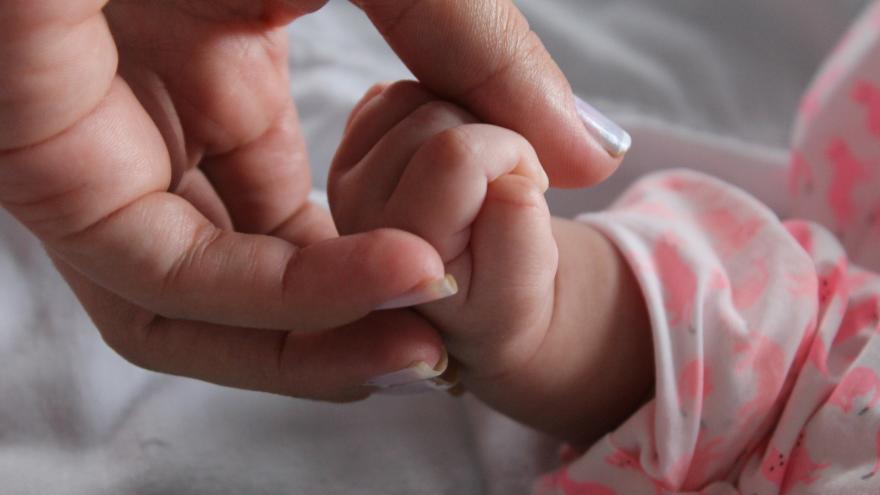 Bebé agarrando dedos de su madre