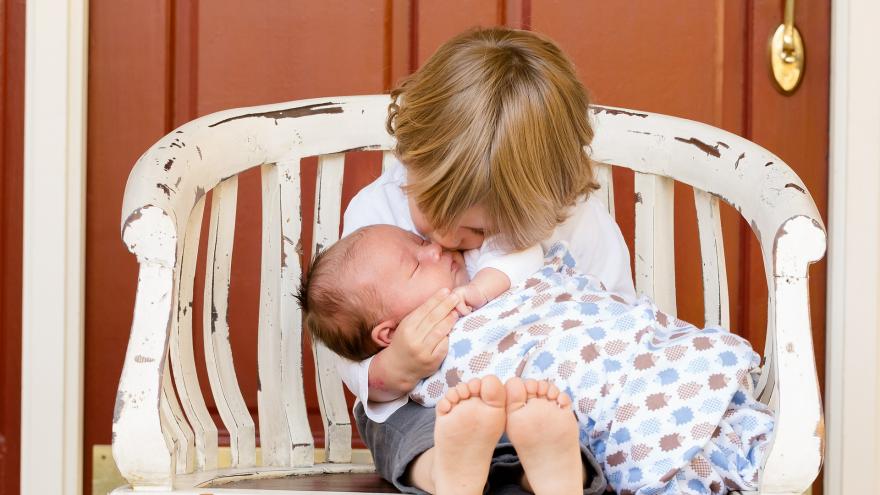 Niño y bebé sentados en un banco