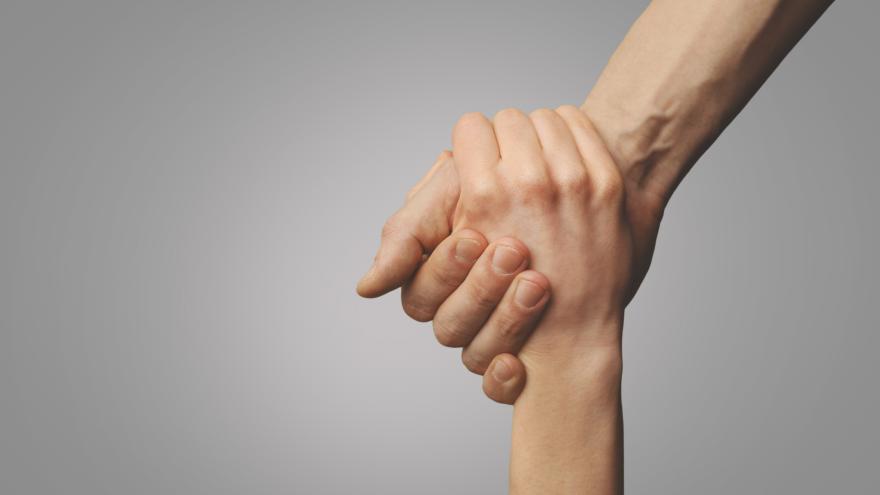 Dos personas se dan la mano, es un primer plano de las manos