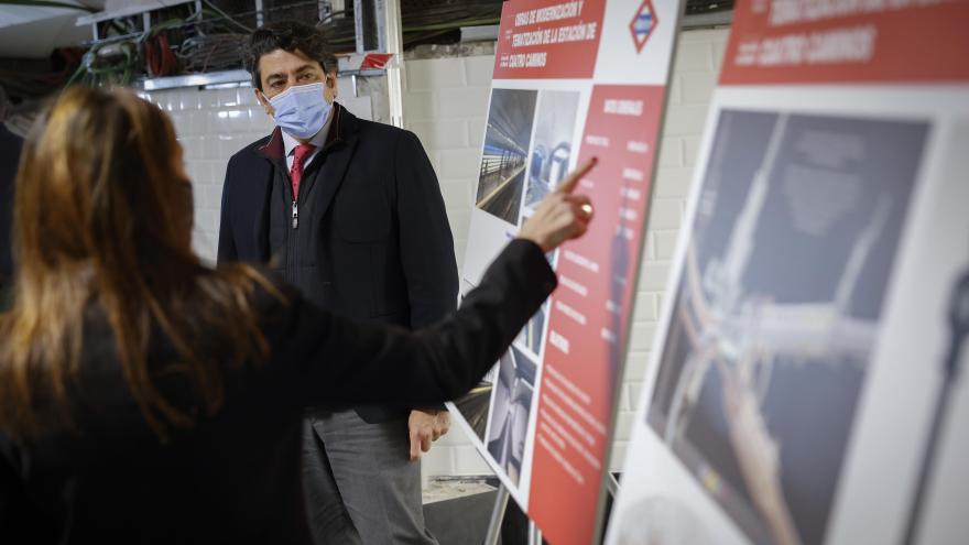 El consejero conversa con una mujer que le señala un cartel sobre las obras