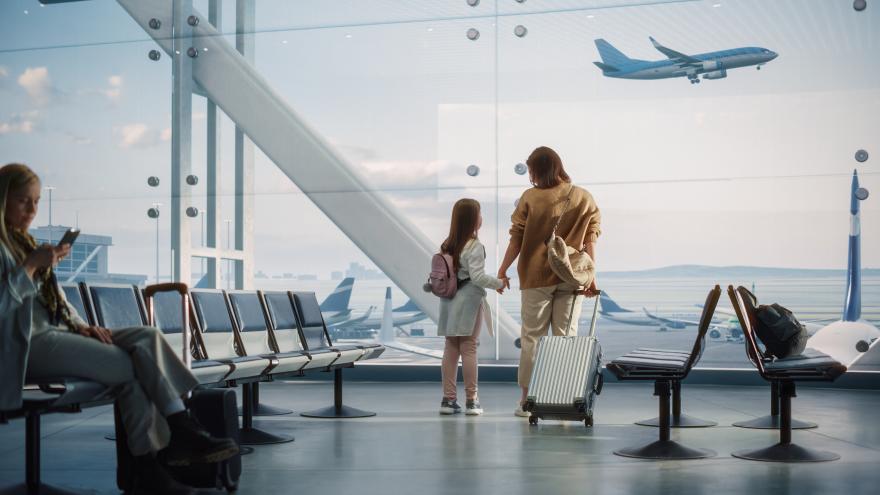 imagen de mujer y niña en aeropuerto con maleta