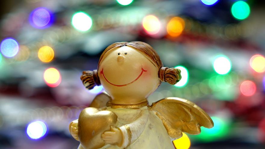 Figurita de un ángel con luces navideñas de fondo