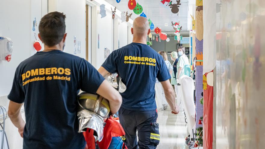 Los bomberos reparten regalos por las habitaciones del hospital
