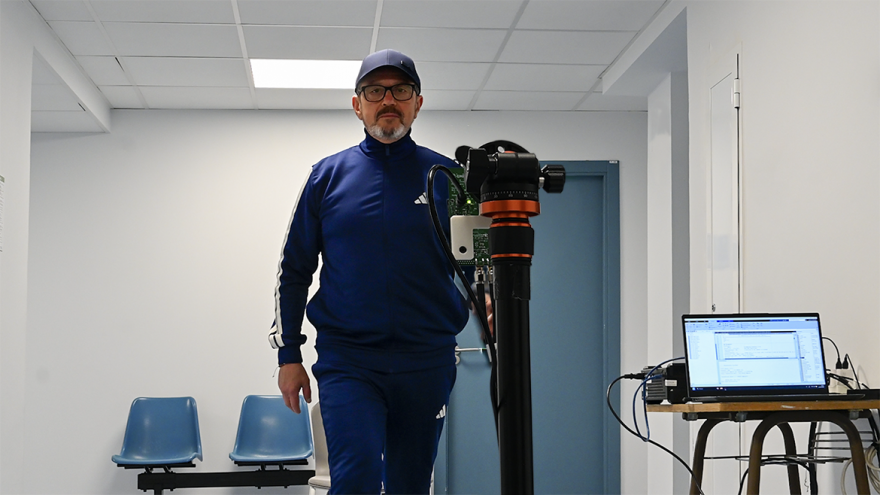 Persona caminando frente a un aparato tecnológico