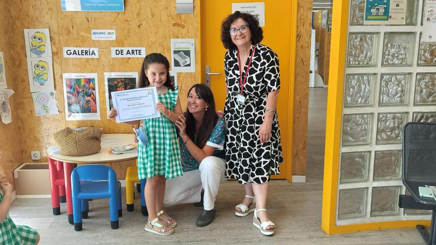 La pequeña ganadora posa con su certificado del primer premio