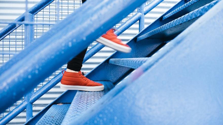 Muestra los pies de una persona subiendo escaleras