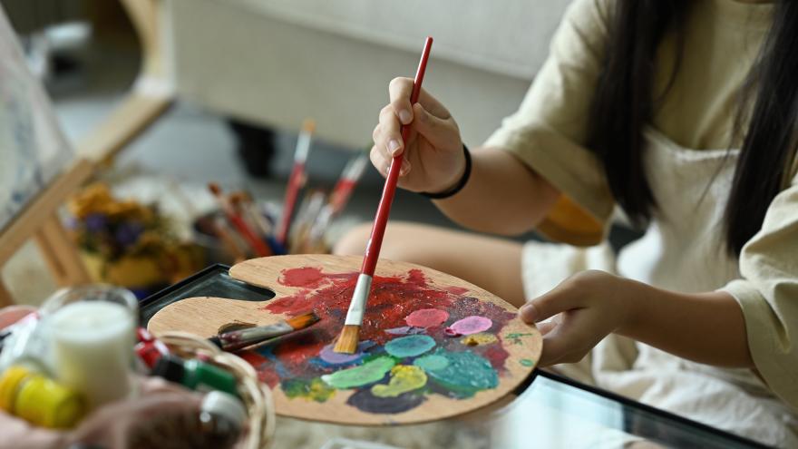 Una estudiante de pintura con sus óleos