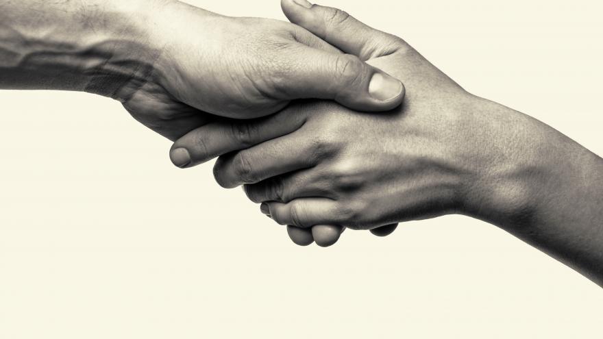 Dos manos unidas en señal de cooperación