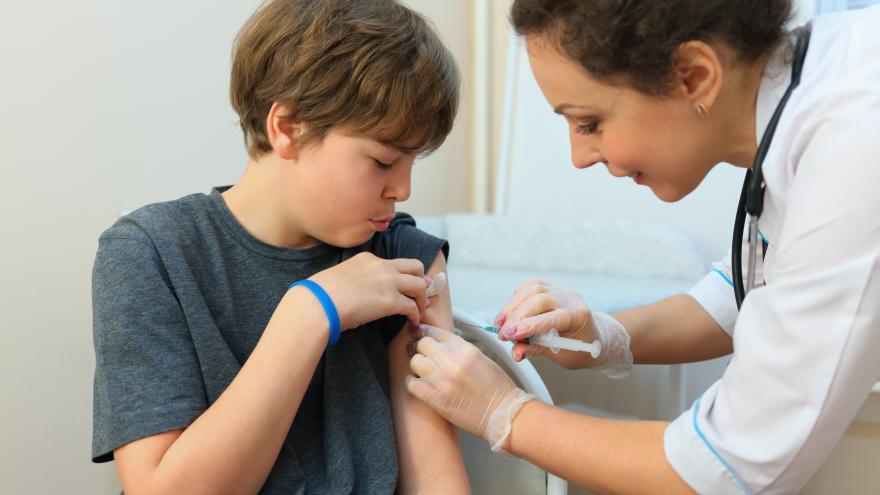 Enfermera vacunando a un adolescente