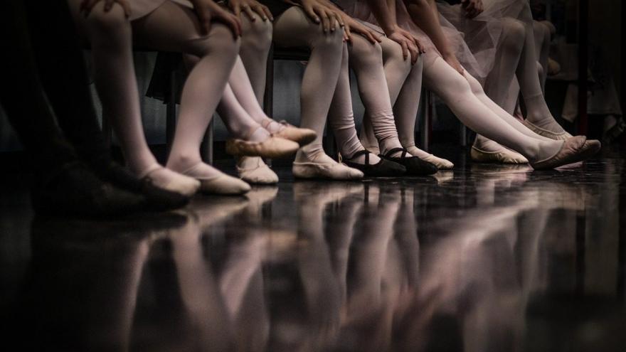 Piernas y pies de bailarinas apoyados en el suelo