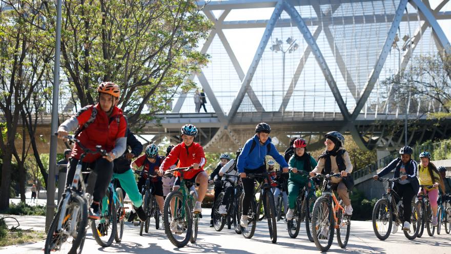 Grupo de adolescentes en bicicleta con la cubierta de un puente al fondo