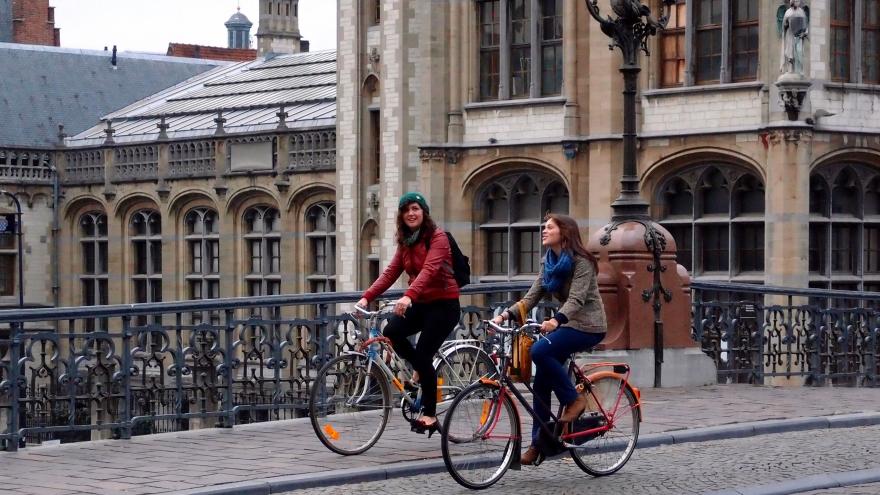 Dos chicas montando en bici por una ciudad