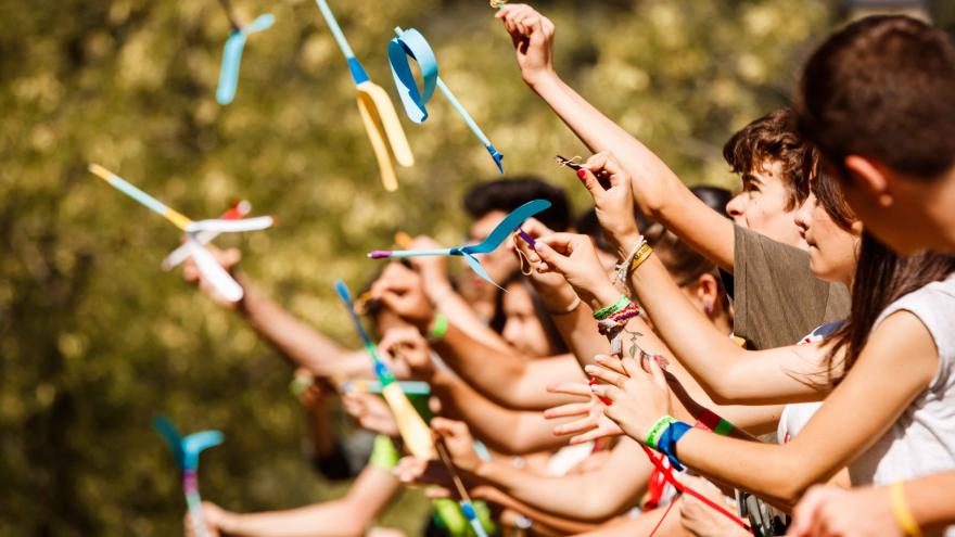 Jóvenes lanzando al aire cintas de colores