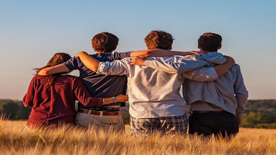 Adolescentes mirando al horizonte en un campo de cereal