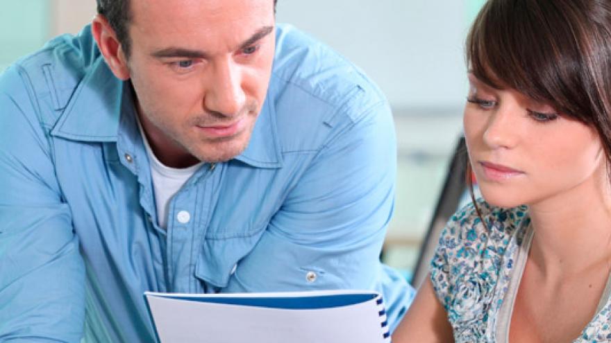 Mujer con discapacidad consultando documentos junto a un compañero