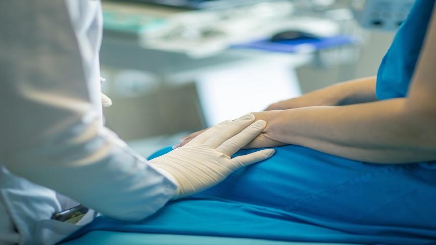 Profesional sanitario apoyando su mano en un paciente
