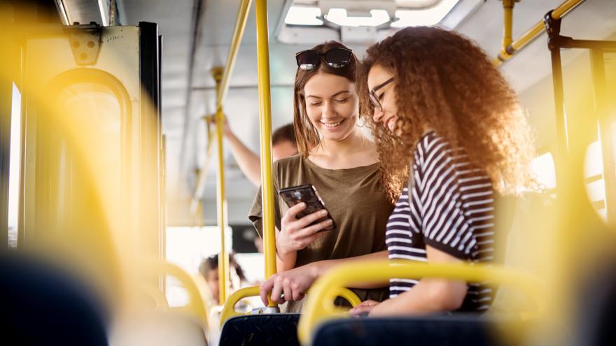 Jóvenes en el autobús mirando el móvil