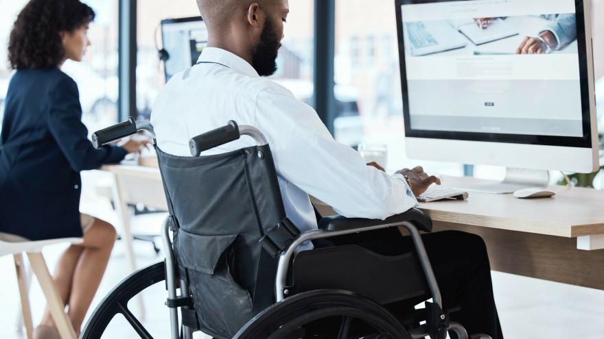 Hombre en silla de ruedas trabajando en un ordenador