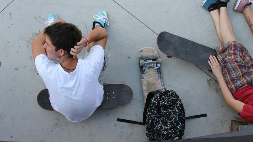 Joven sentado en monopatín