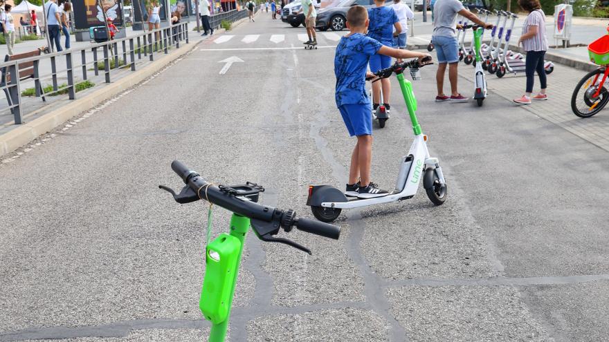 Persona con patinete sobre calzada