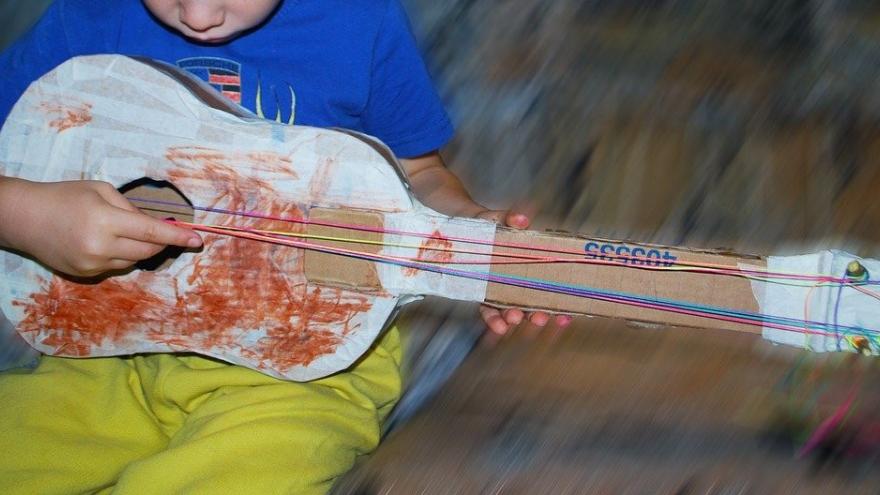 Niño tocando guitarra cartón gomas