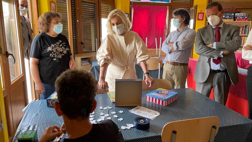 La consejera hablando con un chico que está de espaldas haciendo un puzzle en una mesa