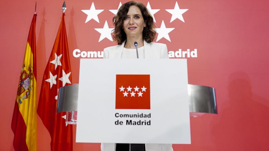 La presidenta delante del atril donde se ve el logo de la Comunidad de Madrid