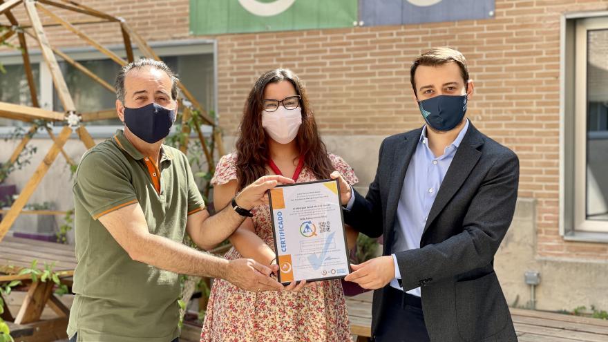 El Director General de Juventud sostiene junto con otro hombre y una mujer un marco con un certificado medioambiental 