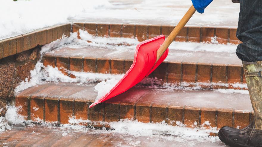 Hombre botas de goma quita nieve pala