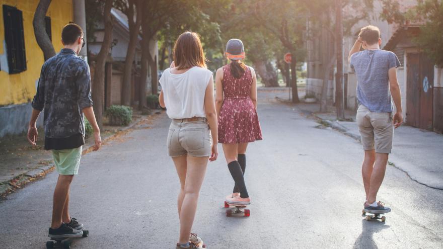 Jóvenes en patinete por una calle