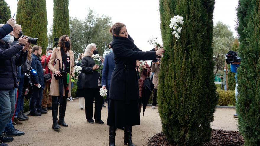 La presidenta coloca las flores blancas en uno de los árboles del Bosque del Recuerdo