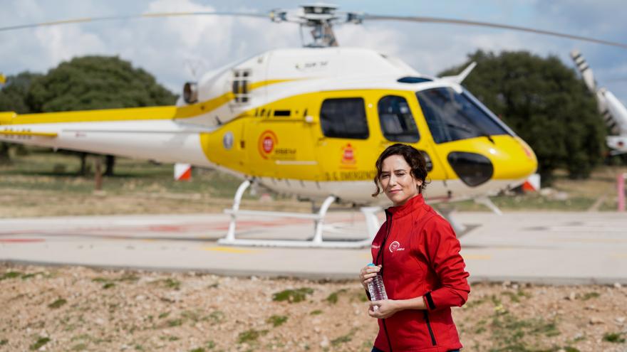 La presidenta caminando delante de un helicóptero