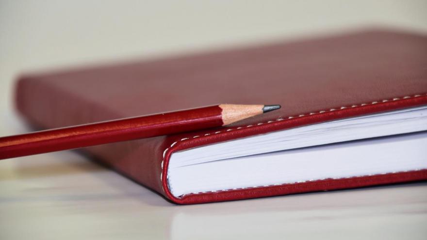Cuaderno y lápiz rojo