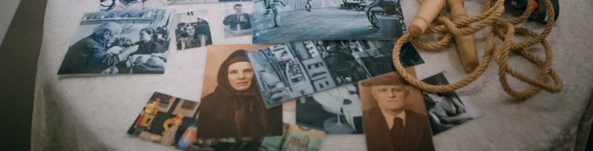 Mesa camilla con fotografías antiguas desordenadas sobre ella