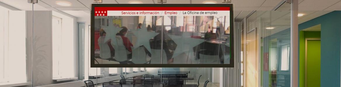 Oficina sin gente con un televisor proyectando la web de la Oficina Virtual de Empleo de la Comunidad de Madrid