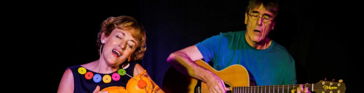 imagen de una mujer y un hombre tocando la guitarra y cantando