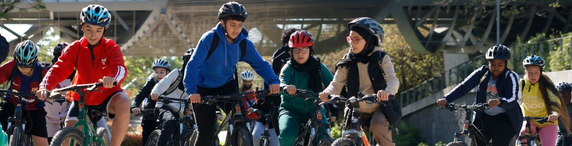 Grupo de adolescentes en bicicleta con la cubierta de un puente al fondo