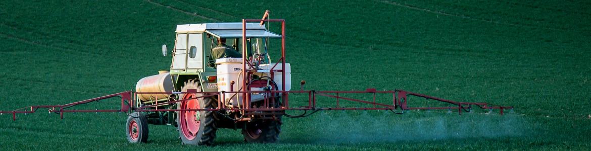 Tractor con aplicador de pesticidas en un campo verde