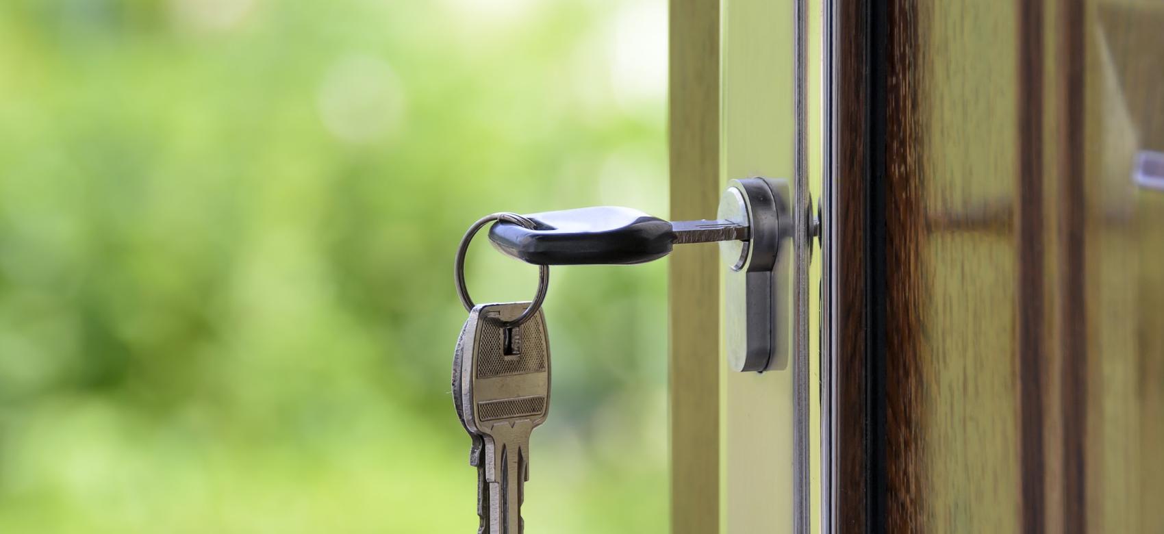 Llave en la cerradura de una puerta abriéndose