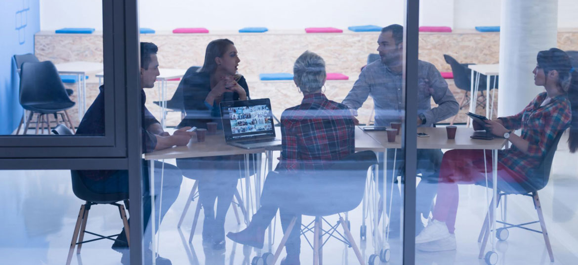 Five people gathered around a work table