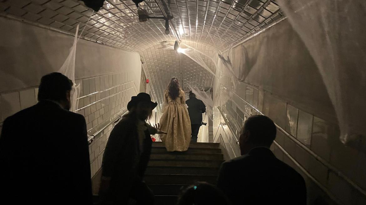 Los personajes disfrazados subiendo una escalera del Metro