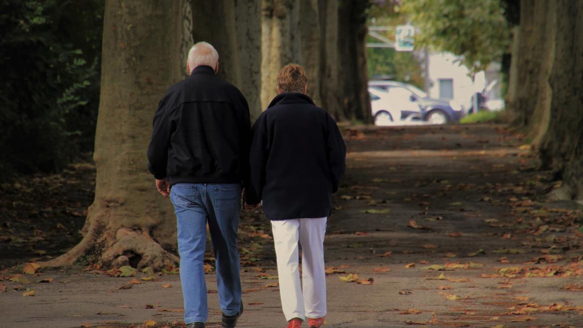 Pareja personas mayores paseando de espaldas 