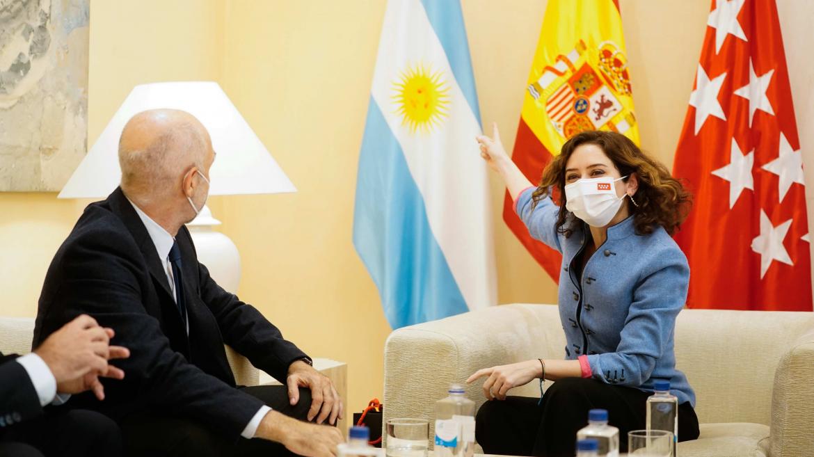 La presidenta sonríe y le señala al jefe de Gobierno la bandera de Argentina