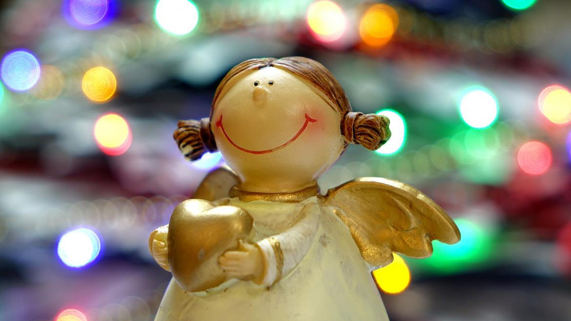 Figurita de un ángel con luces navideñas de fondo