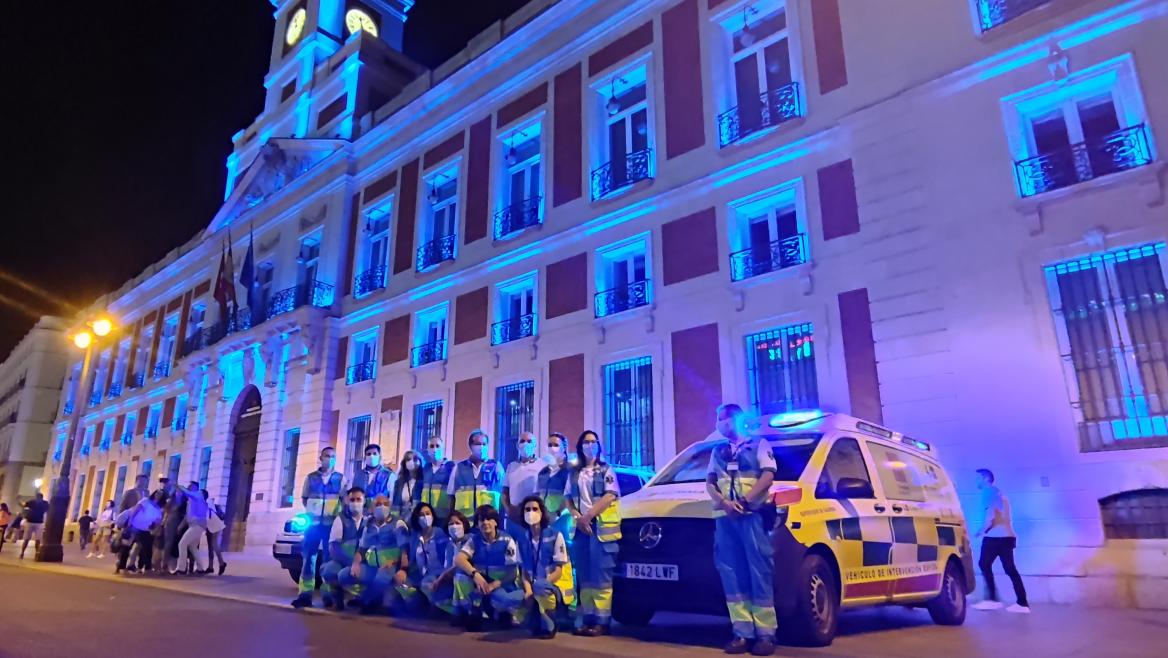 Imagen de grupo de profesionales del SUMMA 112 ante la fachada iluminada de la Real Casa de Correos