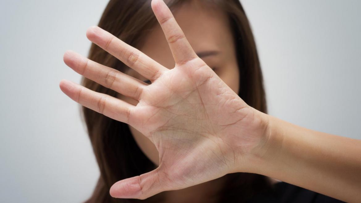 Una mujer se tapa la cara con la mano