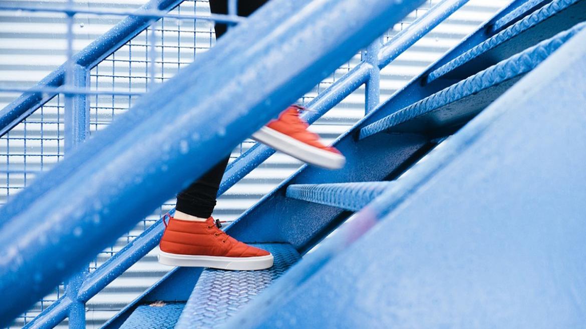 Muestra los pies de una persona subiendo escaleras