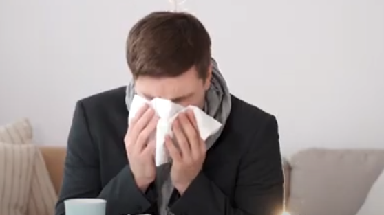 Hombre estornudando y limpiándose con un pañuelo