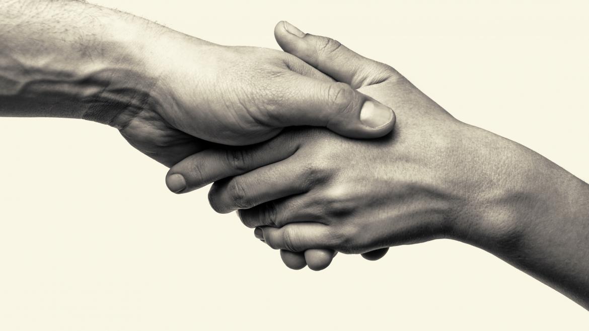 Dos manos unidas en señal de cooperación